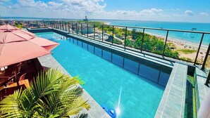Una piscina infinita en la azotea con vistas a la playa y al océano.