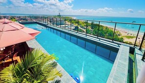 Una piscina infinita en la azotea con vistas a la playa y al océano.