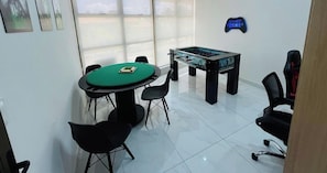 A room with a pool table, a green oval table, and a gaming area. - LM DVA Cabedelo (Cabedelo)