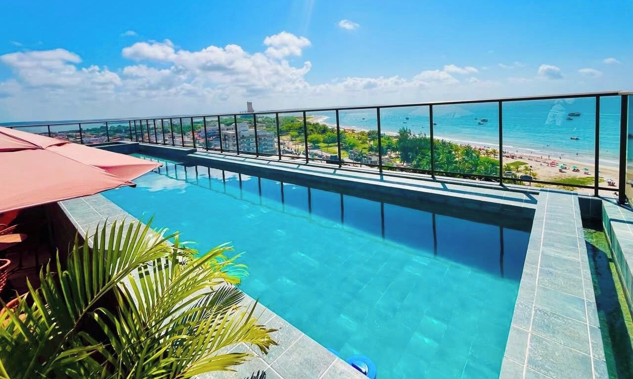 A rooftop infinity pool with a clear view of the beach and ocean.