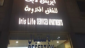 Un edificio con un letrero que indica Apartamentos Iris Life con servicios y una zona de recepción.