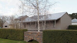 A house with a stone bridge, a wooden porch, and a well-maintained hedge. - RIVER HOUSE - MODERN COUNTRY HOME, LAURISTON (Lauriston)