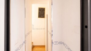 A hallway with a staircase leading to a room, a sign on the wall, and decorative patterns on the walls. - ALL Vecchia Bari | Historic Charm in the Heart of Old Town (Bari)