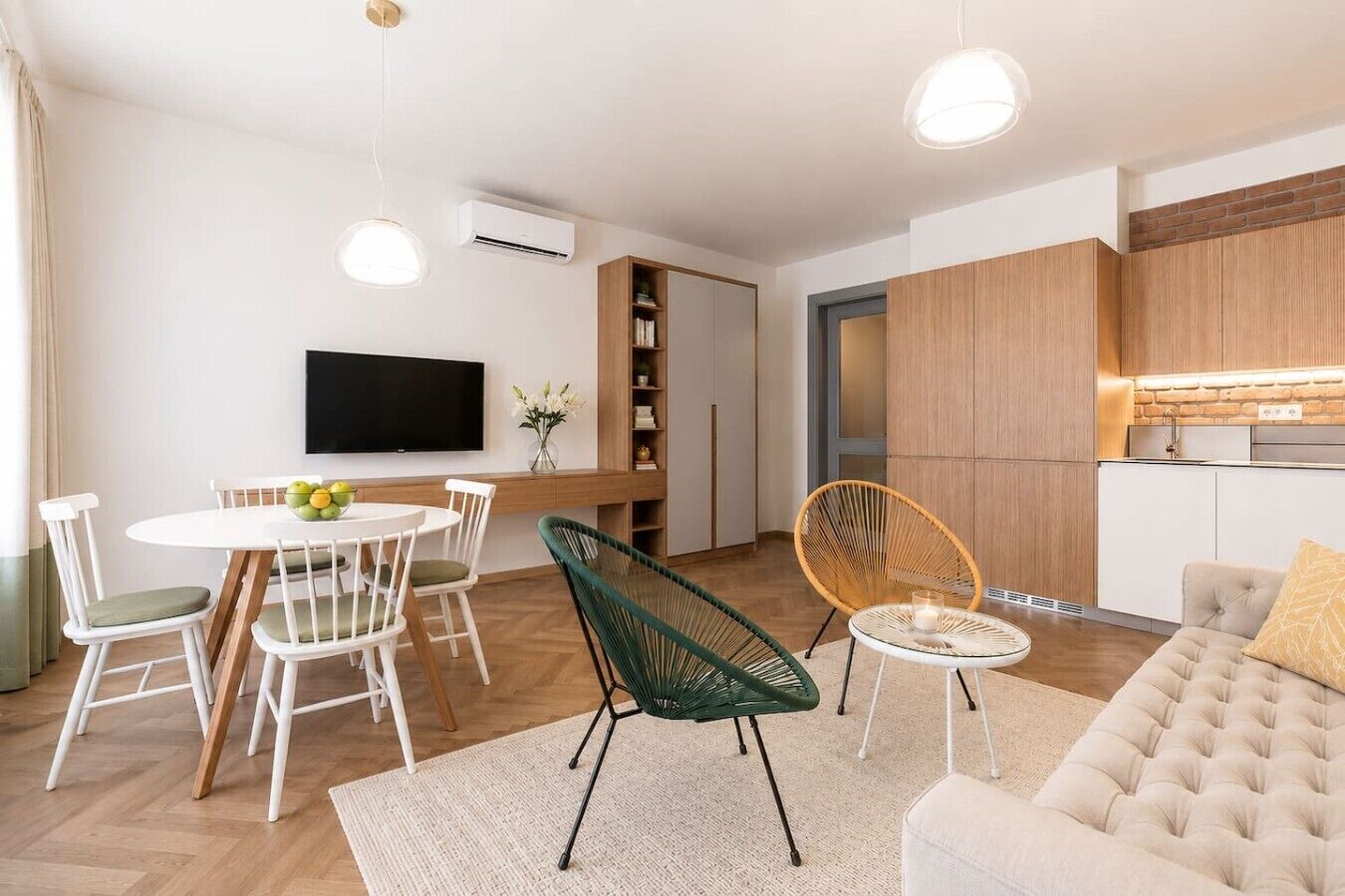 Un soggiorno moderno con divano, tavolo da pranzo, sedie e televisione.