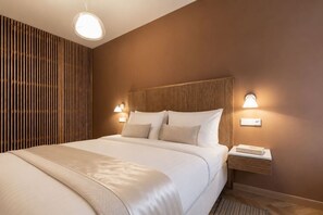 Ein Hotelzimmer mit einem großen Bett, zwei Nachttischen und einer Wandleuchte.