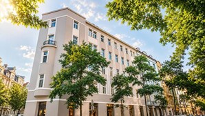 A multi-story hotel with a modern facade, large windows, and a corner entrance. - Modern City Apartment (Prague 2)
