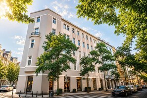 Ein mehrstöckiges Hotel mit moderner Fassade, großen Fenstern und einem Eingang im Winkel.