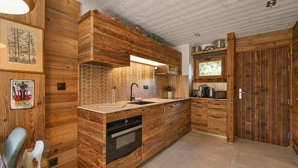 A kitchen with wooden cabinetry, a built-in oven, and a countertop with a sink.