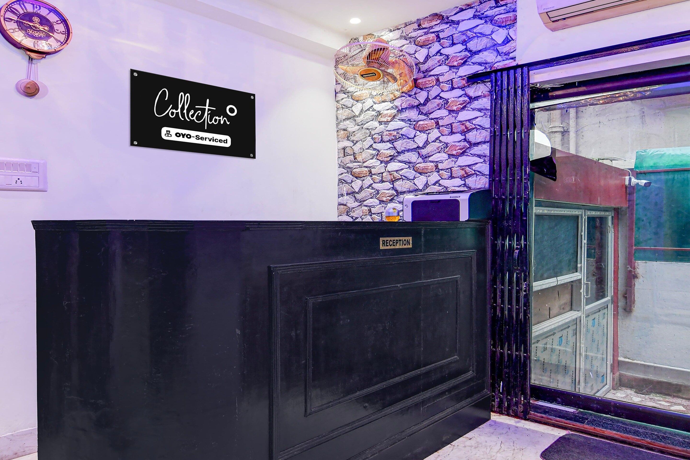 A reception desk with a 'Collection' sign, a stone wall, and a reception area.