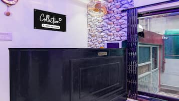 Una reception con una insegna 'Collection', un muro in pietra e l'area dedicata all'accoglienza.