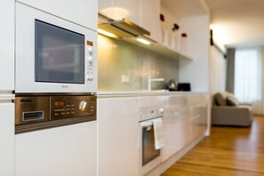 A modern kitchen with a built-in microwave, oven, and a digital control panel. - Riverside Urban Oasis • AC • Stylish Karlín (Karlín)