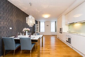 A modern kitchen with white cabinets and a built-in oven. - Riverside Urban Oasis • AC • Stylish Karlín (Karlín)