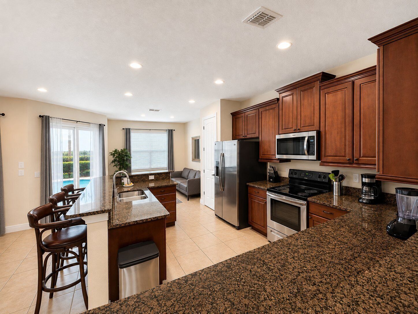 A modern kitchen with granite countertops, stainless steel appliances, and wooden cabinets.
