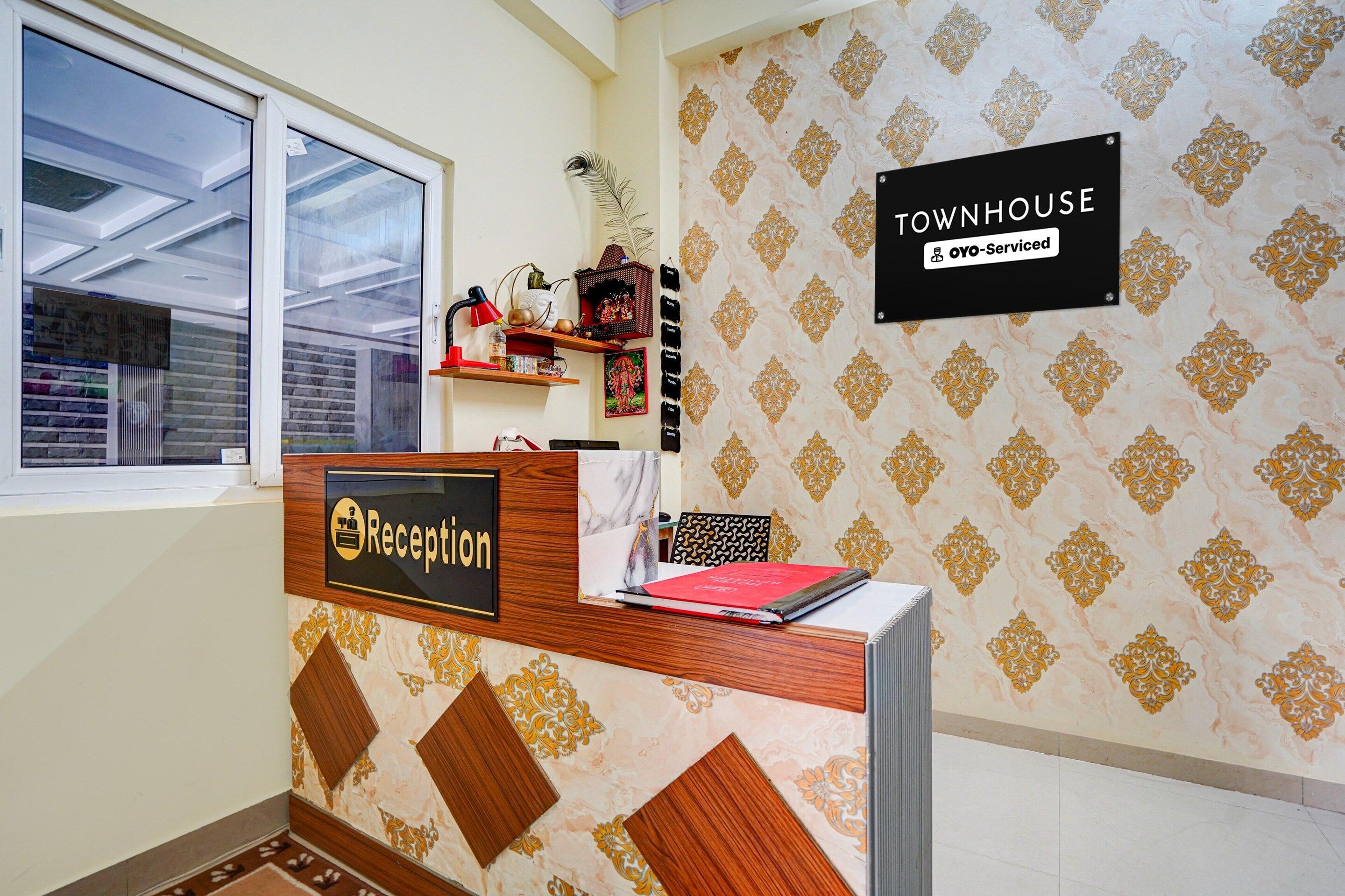 A reception desk with a sign indicating 'Reception' and 'Townhouse OYO-Serviced.'