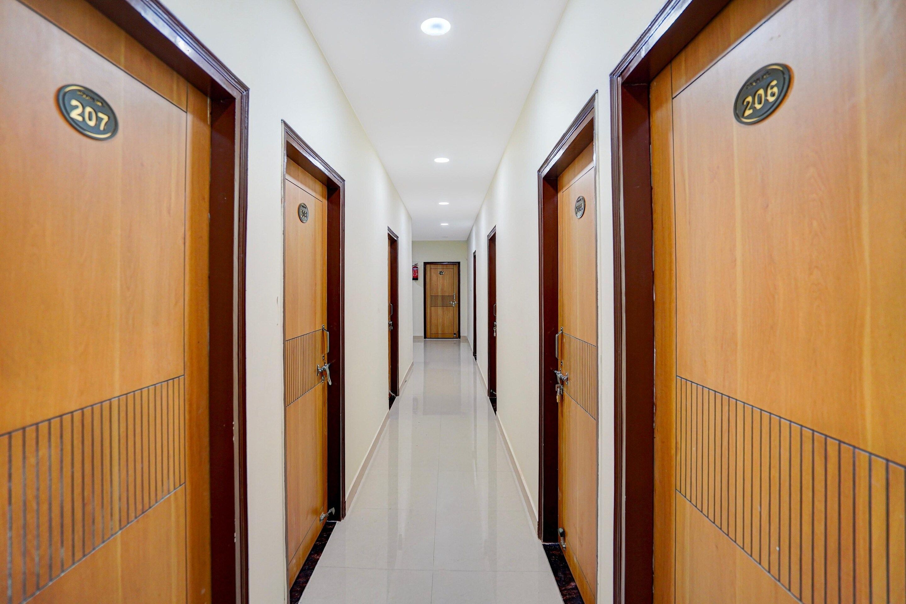 A hotel corridor with wooden doors numbered 207 and 206.