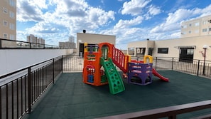 A rooftop playground with a slide and climbing structures.