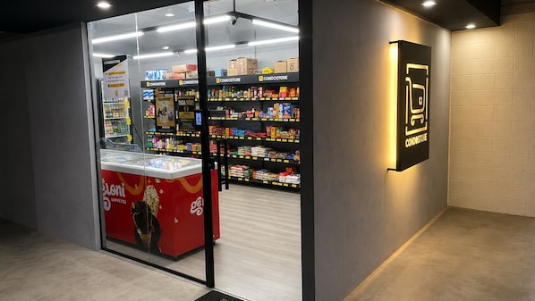 A modern interior with a refrigerated display for ice cream and shelves stocked with various products.