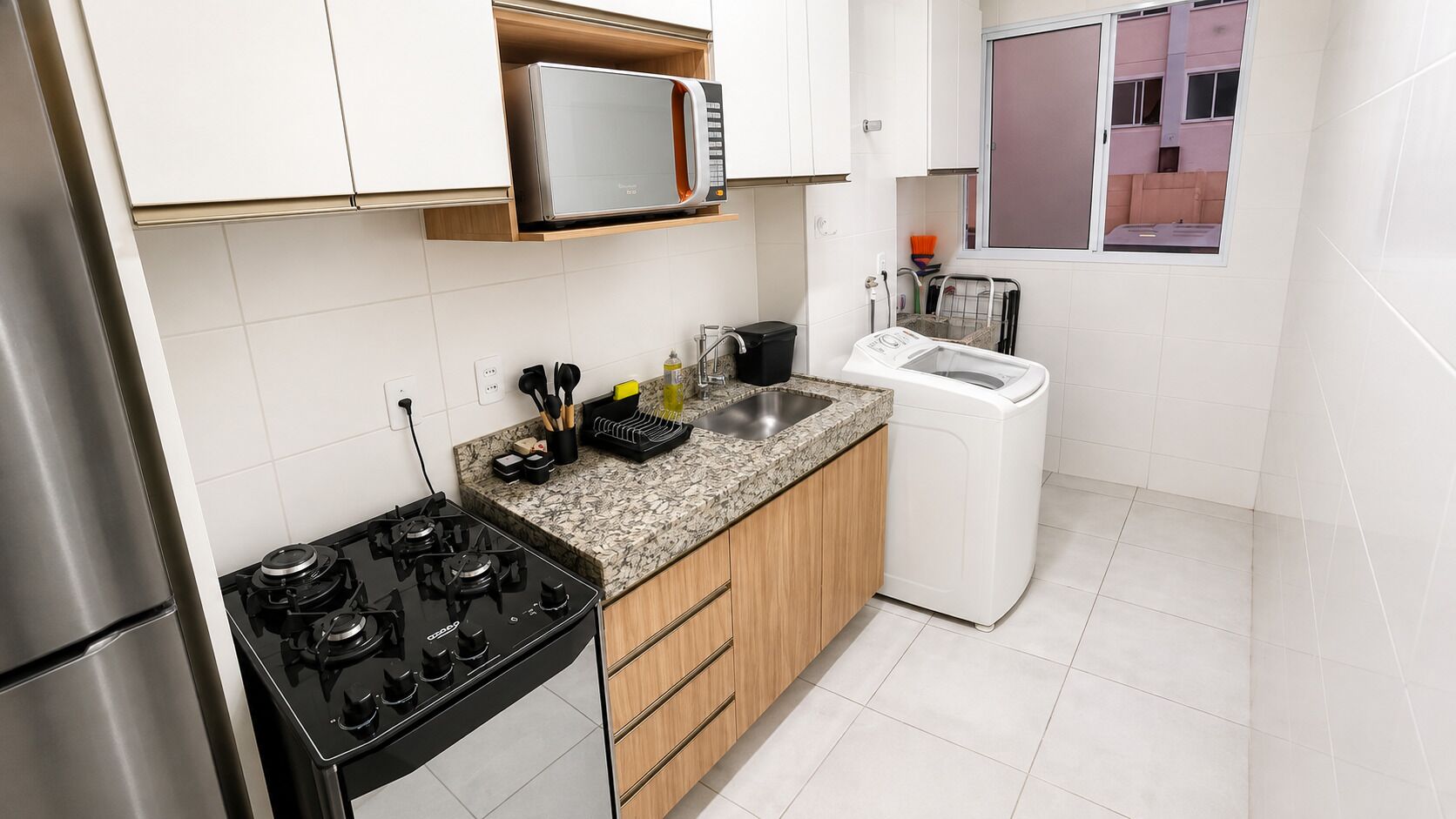 A compact kitchen with a gas stove, a microwave, and a built-in dishwasher.