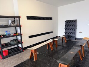 A room with a black metal shelf unit, a bench, a table, and a wall-mounted rack. - 4-bedroom condo on Lone Peak mountain.  Not near the mountain. On it! (Big Sky)