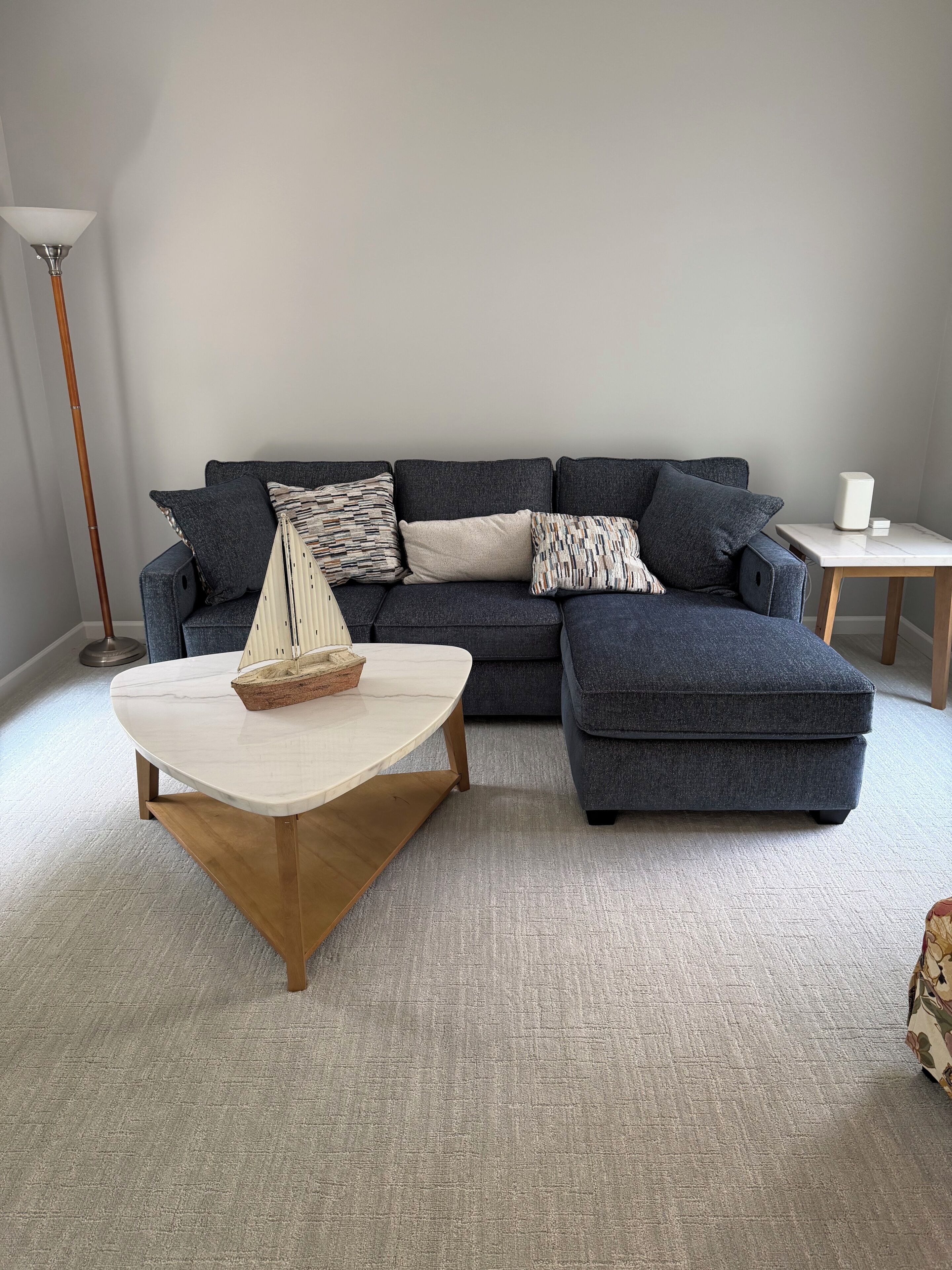 A living room with a sectional sofa, a coffee table, and a floor lamp.