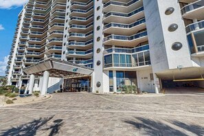 Ein mehrstöckiges Hotel mit moderner Architektur, das einen markanten Eingangsbereich mit Überdachung und eine Tiefgarage bietet.