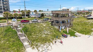 Ein Strandhotel mit Rettungsturm, einer Promenade, die zum Strand führt, und einem Schild mit der Aufschrift Surfside.