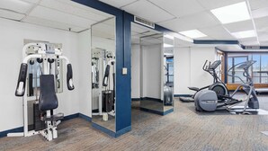 A gym with exercise equipment, a mirrored wall, and a view of the outdoors. - Beach View Studio with Private Balcony, Pool, Hot Tub & Resort Access (Miramar Beach)
