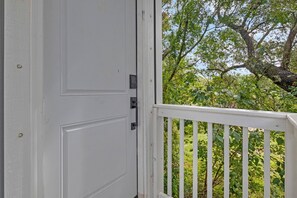 A white door with a black handle, leading to a balcony with a white railing. - The Graffiti Loft - Artsy 1BR Near Downtown Pensacola (Pensacola)