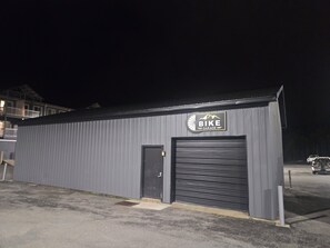 A building with a sign reading 'BIKE GARAGE' and a closed garage door. - Ski IN/Ski OUT Snowshoe Rental (Snowshoe)