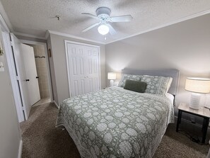 A bedroom with a bed, a nightstand, a ceiling fan, and a door. - Ski IN/Ski OUT Snowshoe Rental (Snowshoe)