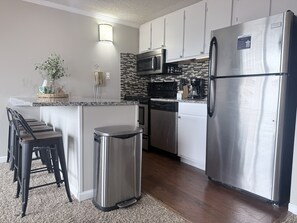 A modern kitchen with stainless steel appliances, a microwave, and a dishwasher. - Ski IN/Ski OUT Snowshoe Rental (Snowshoe)