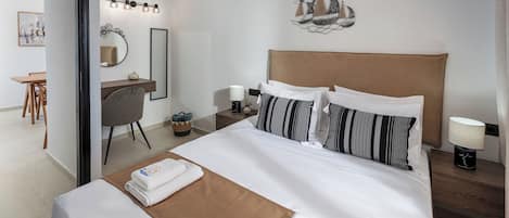 A hotel room with a bed, bedside tables, a desk, and a chair.