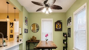 A dining area with a wooden table, benches, and a ceiling fan.