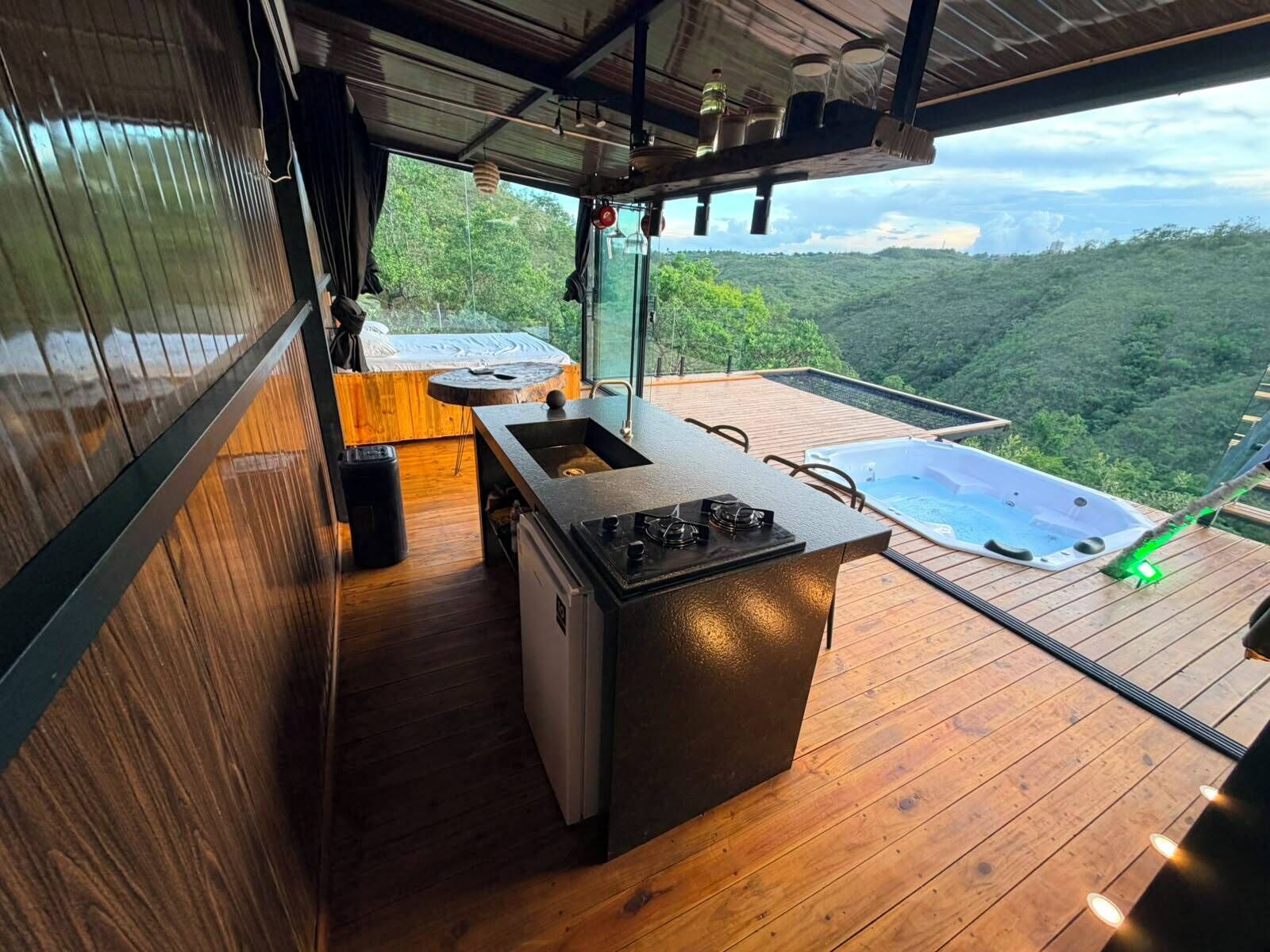 Una cocina moderna con un ventanal grande, un jacuzzi y vistas a un paisaje boscoso.