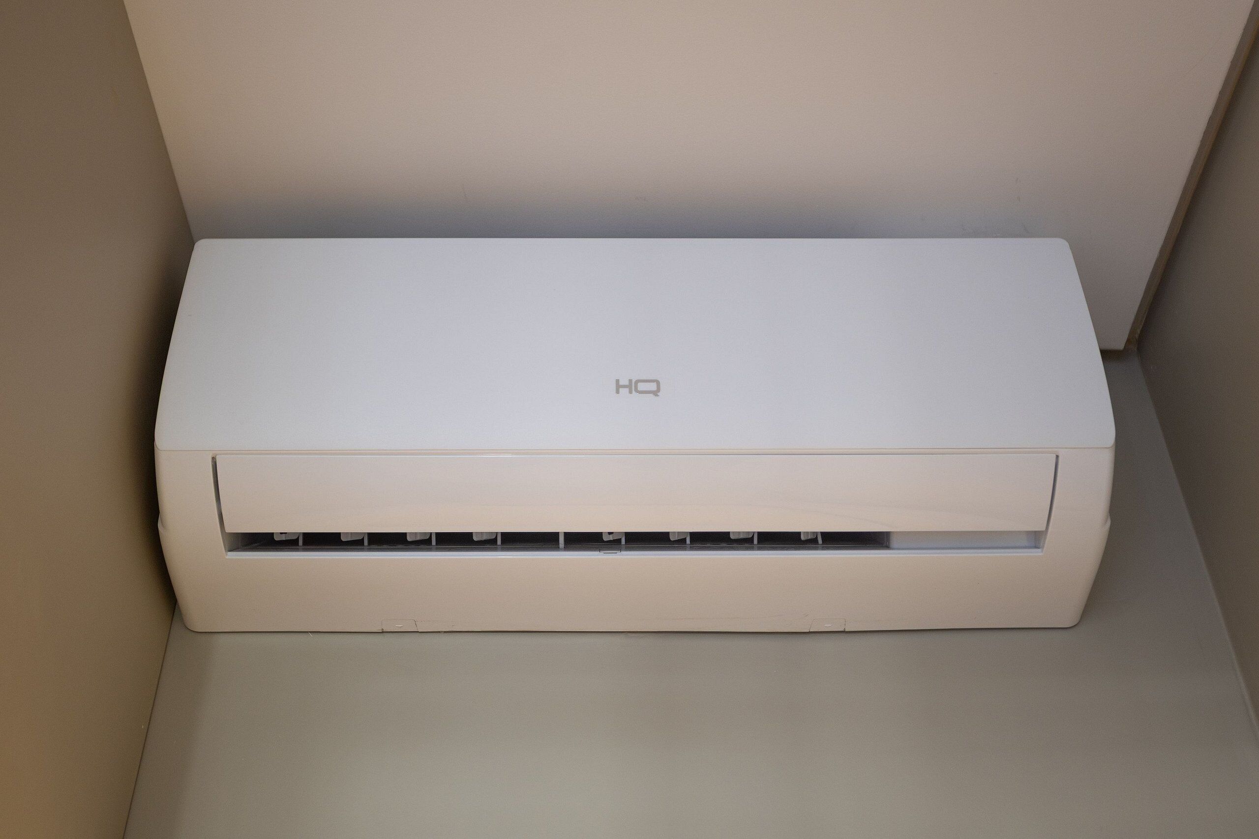 A white portable air conditioner with the brand 'HQ' on the top.