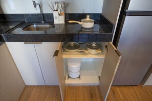 Ett kök med en diskho i rostfritt stål, en kastrull på spisen och en inbyggd ugn.