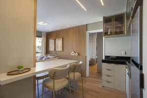 Eine moderne Küche mit Kochinsel, Barhocker und integriertem Backofen.