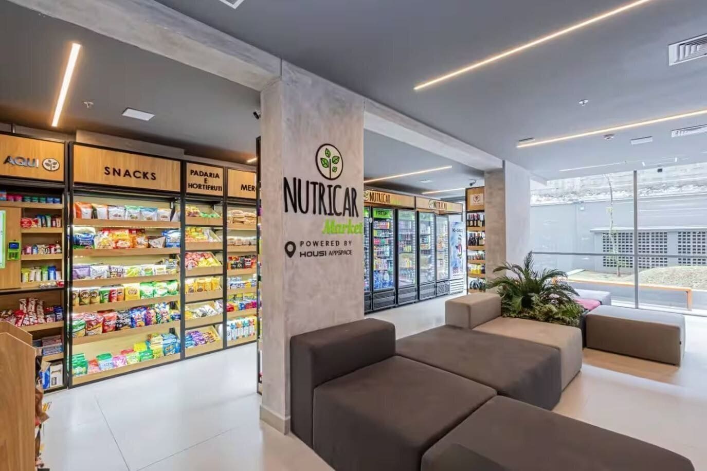 Un interior moderno con una sección 'NUTRICAL', zonas de estar y vistas amplias a través de grandes ventanales.