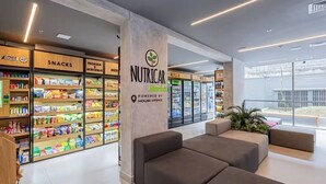 A modern interior with a 'NUTRICAL' section, seating areas, and a view through large windows. - ON Augusta (São Paulo)