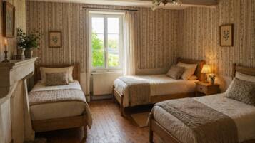 Un dormitorio tradicional con dos camas individuales, una ventana y un radiador.