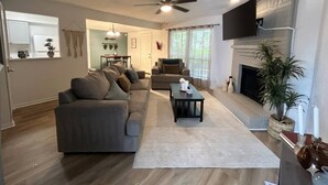 A modern living room with a sofa, a coffee table, and a fireplace. - Welcoming 2-bedroom house with AC in Arlington, near AT&T Stadium &Six Flags (Arlington)