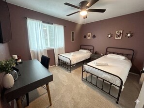 A bedroom with two beds, a desk, and a ceiling fan. - Welcoming 2-bedroom house with AC in Arlington, near AT&T Stadium &Six Flags (Arlington)