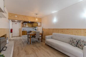 A modern kitchen with wooden cabinets and a dining area with a table and chairs. - #400 Central Albufeira Oasis | 1BR & Pool (Albufeira)