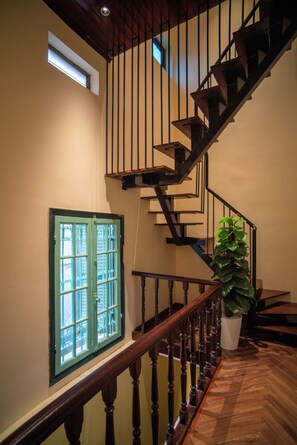 A staircase with wooden railings and a potted plant. - DoDo Apartments (Ha Noi)