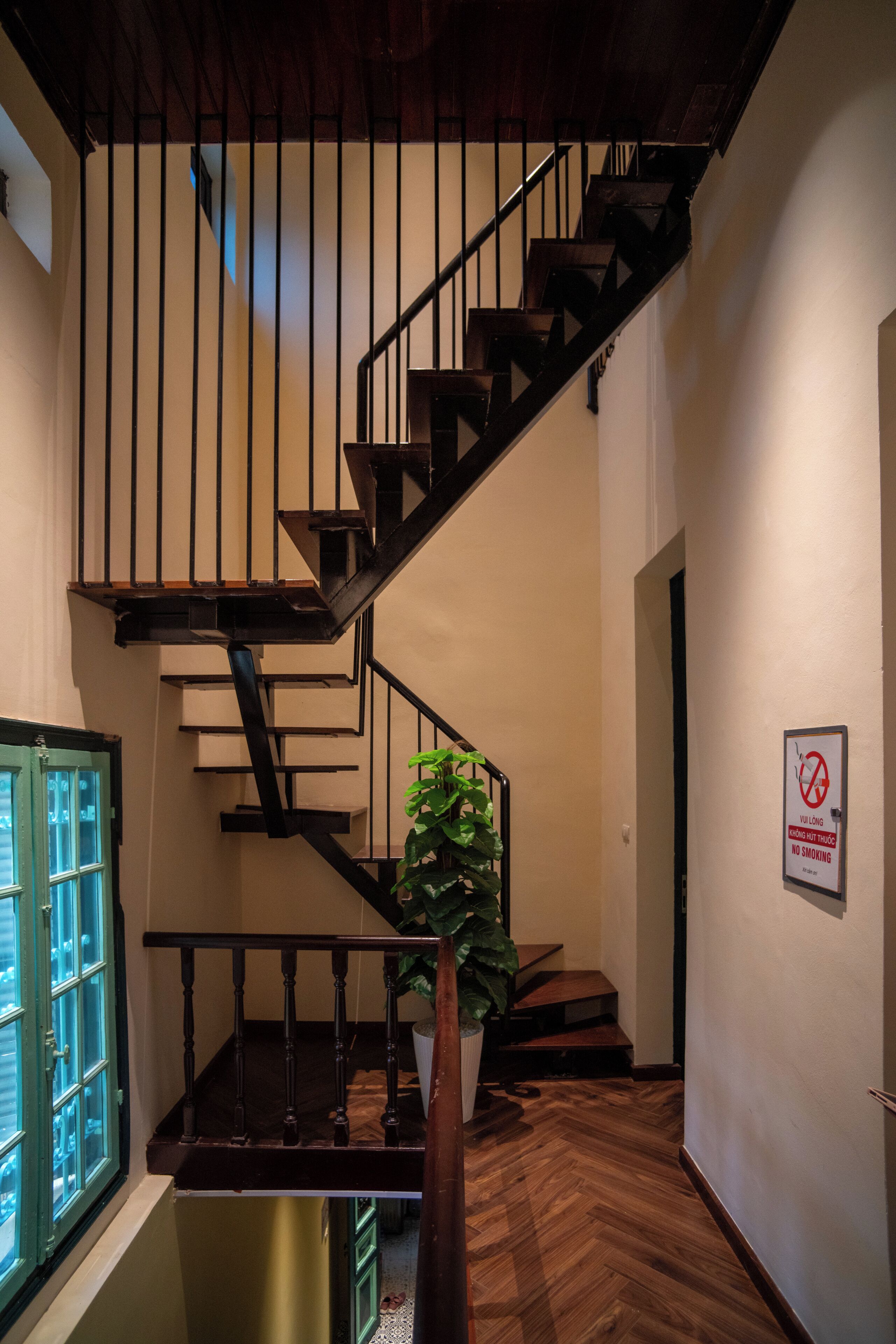 Una escalera de madera con barandillas negras que conduce a un piso superior.