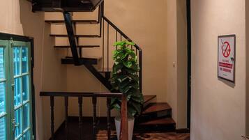 Una escalera de madera con barandillas negras que conduce a un piso superior.