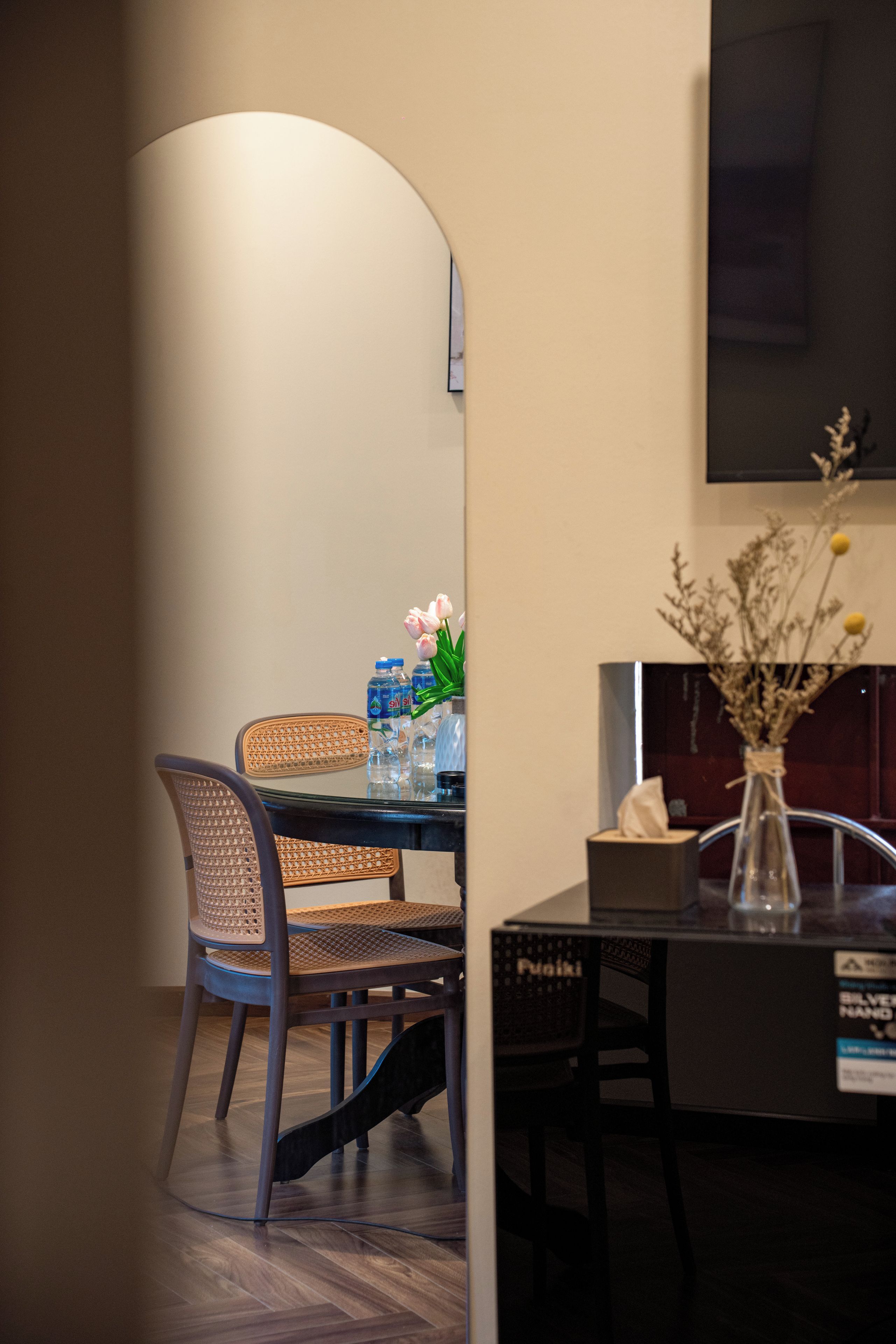 Un coin repas avec une table, des chaises et un vase de fleurs.
