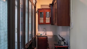 Una cocina estrecha con armarios de madera, un lavamanos y una estufa.