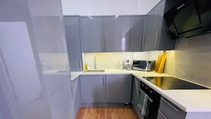 A modern kitchen with grey cabinets, a stainless steel microwave, and a wooden floor. - Apartment Sleeps 4 - Wifi, Close to Football Club (Ipswich)