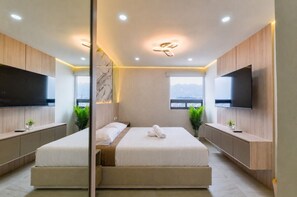 A modern bedroom with a large bed, two TV screens, and a city view. - ¡Céntrico & Nuevo! Gym, Parking & Pool - 6G 2BR2br (Monterrey)
